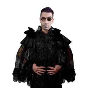 A picture of a man wearing a feathered cloak and he has glasses on with one of the lenses being tinted