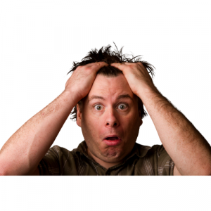 A picture of a man holding his head, looking shocked