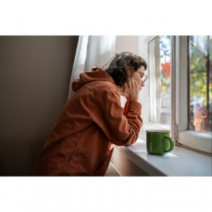A picture of a woman looking out of a window.
