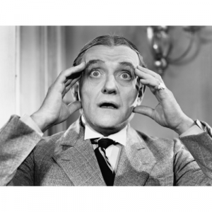 A black and white photo of a man holding his temples as if he's reading someone's mind.