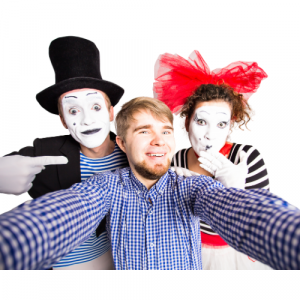 A picture of a man stood with two mime artists.